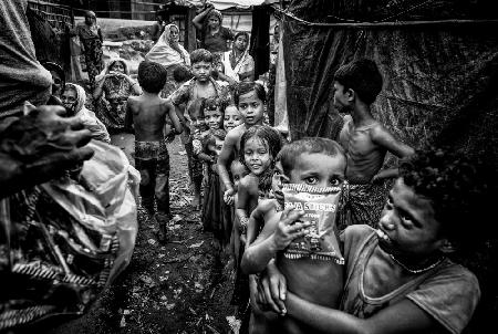 Rohingya-Flüchtlingskinder stehen Schlange,um Snacks zu bekommen – Bangladesch