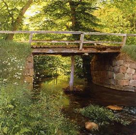 Holzbrücke über einem Flüsschen 1900