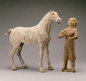 A Painted Grey Pottery Group Of A Horse And Groom
