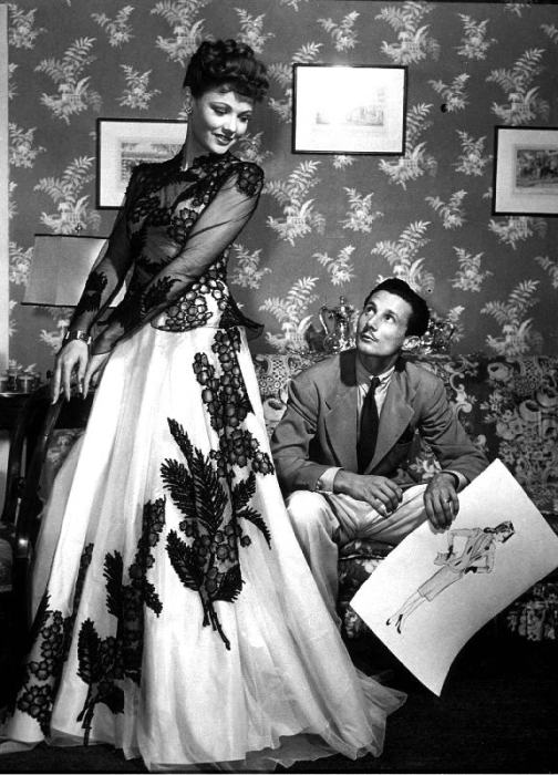 fashion designer Oleg Cassini showing his drawings to Gene Tierney to show her the clothes for film  von 
