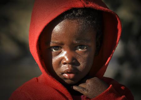 Der Junge im roten Mantel in Namibia