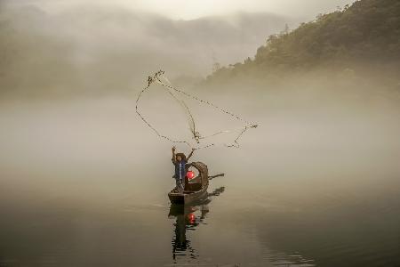 Ein Fischer im Morgennebel