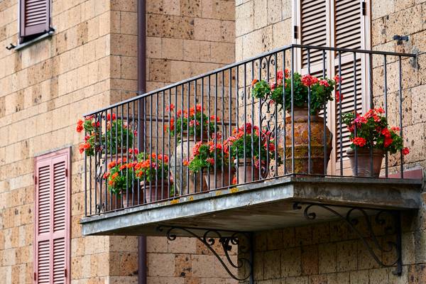 Romantischer Balkon mit roten Blumen in Tonkrügen von Robert Kalb