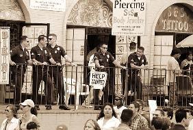 Police gathered behind a ''Help Wanted'' sign, 2004 (b/w photo) 