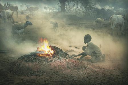 MUNDARI-SÜDSUDAN Junge und sein Feuer