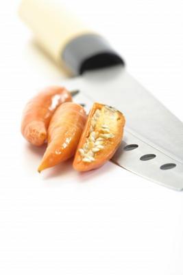 Gelbe Peperoni mit Messer
